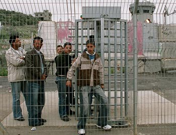 The �Azzun 'Atmah gate in the Separation Barrier. The guard tower where soldiers are posted at night is visible in the background. Photo: Miki Kratzman. 