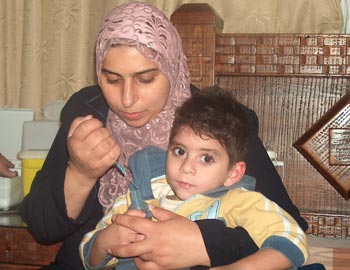 Jihan A-Shanti caring for her son Muhammad . photo: Muhammad Sabah, B'Tselem.