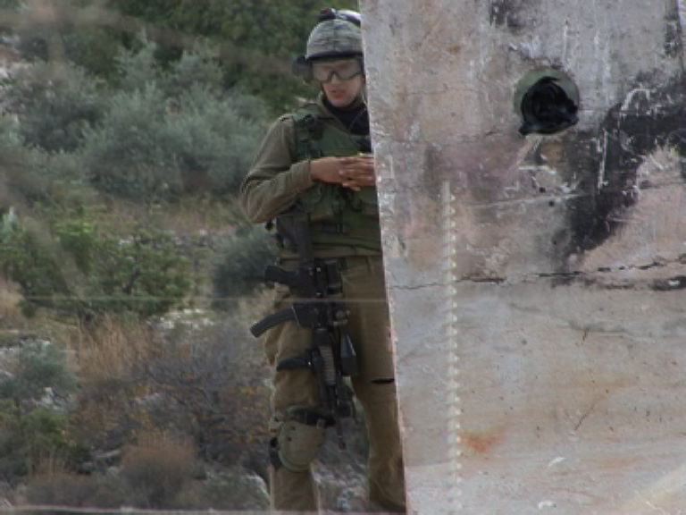 Army sniper holding a rifle loaded with 22-caliber bullets. Photo from B'Tselem video.