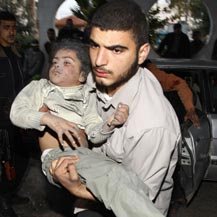 חובש מפנה ילדה שנפצעה מפגיעת טיל בבית בעזה. צילום: מוחמד סאלם, רויטרס.