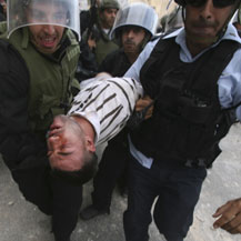 שוטרים סוחבים את פיראס אל-אטרש במזרח ירושלים. לפי עדותו של אל-אטרש הוא הוכה קשות בידי שוטרים. צילום: באז רטנר, רויטרס, 9.10.09.