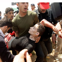Ahmad Dib, 19, wounded by Israeli security forces' fire while demonstrating near the Gaza-Israel border fence, being taken to hospital in Gaza. Photo: Reuters, 28 April' 10.