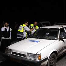 Israeli ZAKA rescue service members near the vehicle which was carrying four Israelis killed in a shooting attack in Hebron area. Photo: Ronen Zvulun, Reuters, 31 Aug. '10.