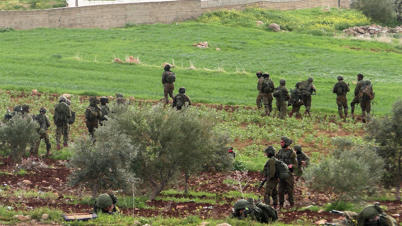 Soldiers train on cultivated field, al-'Aqabah. Photo by: ‘Aref Daraghmeh, 15 Feb. 2018
