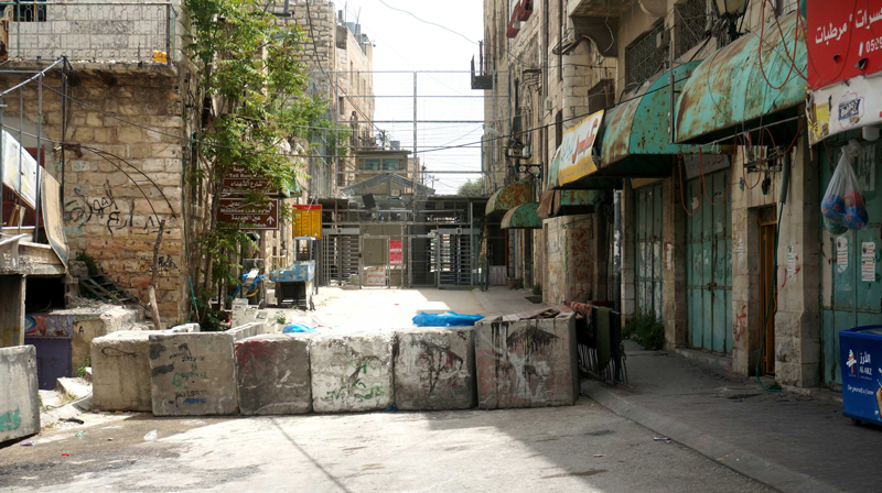 The reinforced Police Bab a-Zawiya/Shoter Checkpoint. It separates the neighborhood of Tel Rumeidah and a-Shuhadaa St. from the eastern neighborhoods of Hebron in Area H1.