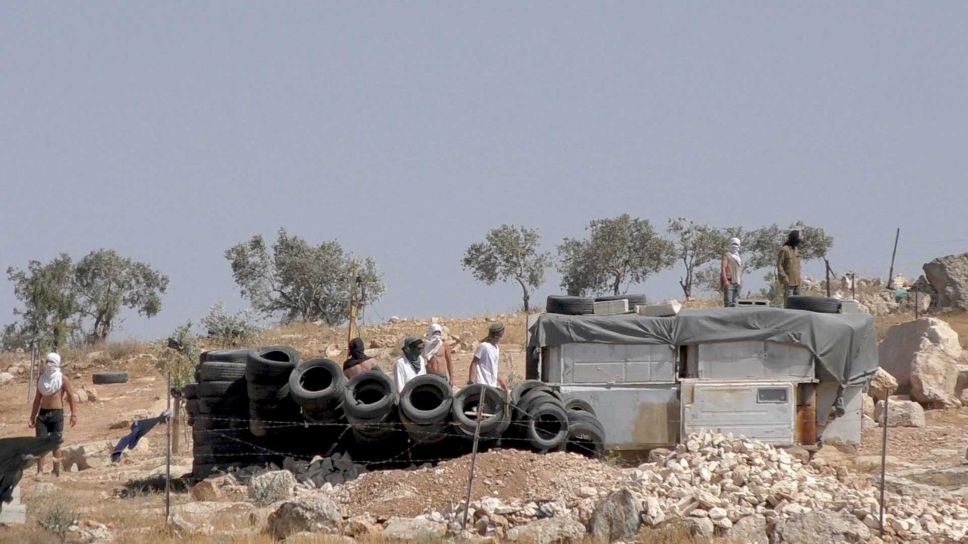 Settlers taking over a Palestinian agricultural structure