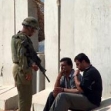 <p>[4851] 19  An Israeli soldier guards two detained Palestinians at the Beit Furik checkpoint.</p><p>Photo credit: Checkpoint Monitors Team, B'Tselem</p>