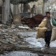 <p>[10643] 9 Jan A Palestinian boy carries pillows as he leaves his house during Israel's offensive nicknamed "Operation Cast Lead", the northern Gaza Strip January 9, 2009.</p><p>Photo credit: Mohammad Salem, © Reuters</p>
