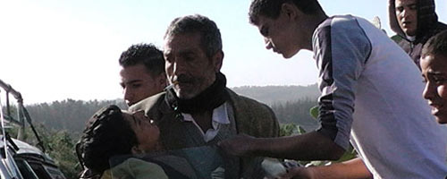 Samir &lsquo;Awad being evacuated from the scene after being shot. Photo: 'Abd a-Nasser Murar