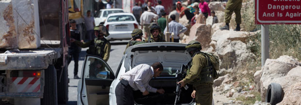 Roadblock at entrance to Hebron. Photo: Baz Ratner, Reuters, 15 June 2014. Israel imposed severe travel restrictions on Hebron District residents, including roadblocks and not permitting Palestinians to enter Israel for work.