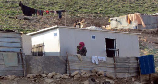 A resident on the al-Ka’abneh community next to one of the prefabricated temporary dwellings provided by the EU. Photo: 'Amer al-Aruri, B'Tselem, 18 Jan. 2015. Click on photo to enlarge