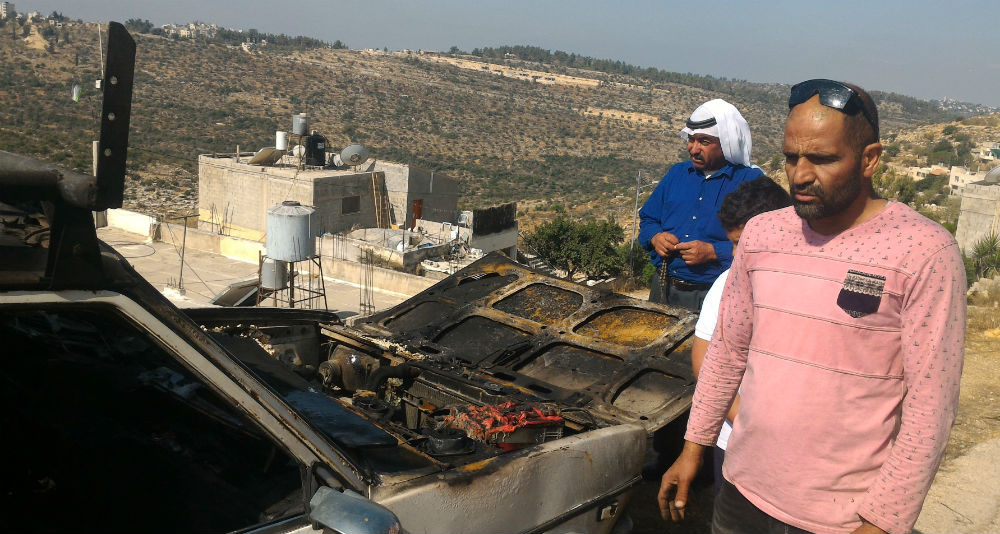 ‘Omar Tanatrah next to his car, which was torched by settlers at Um Safa. Photography: Iyad Hadad, B’tselem . 9.8.17 ‘Omar Tanatrah next to his car, which was torched by settlers at Um Safa. Photography: Iyad Hadad, B’tselem . 9.8.17