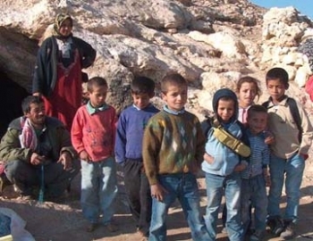 Palestinian children at the entrance to a cave home in the Southern Hebron Hills	. Photo: Musa Abu Hashhash, B'Tselem, 13 December 2004. 