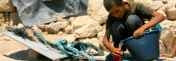 Boy draws water from cistern in the village of Khirbet Jenbah, South Hebron Hills, which is not hooked up to water grid. Photo by Sharon Azran, B&rsquo;Tselem, 7 August 2012