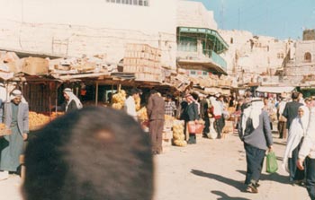 سوق الفواكه في الخليل. من الاعلى: في سنوات التسعين. من الاسفل: عام 2007. تصوير: نايف هشلمون، مركز الوطن وكيرين مانور، اكتيبستيلس.
