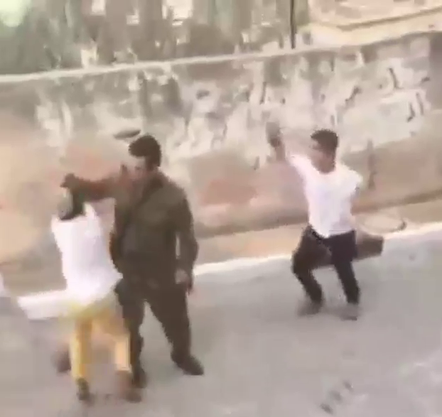 A soldier confronts settler children who threw stones at Palestinians in Tel Rumeidah, Hebron, 5 Sep. 2020. Photo: Nadiah Jaber.