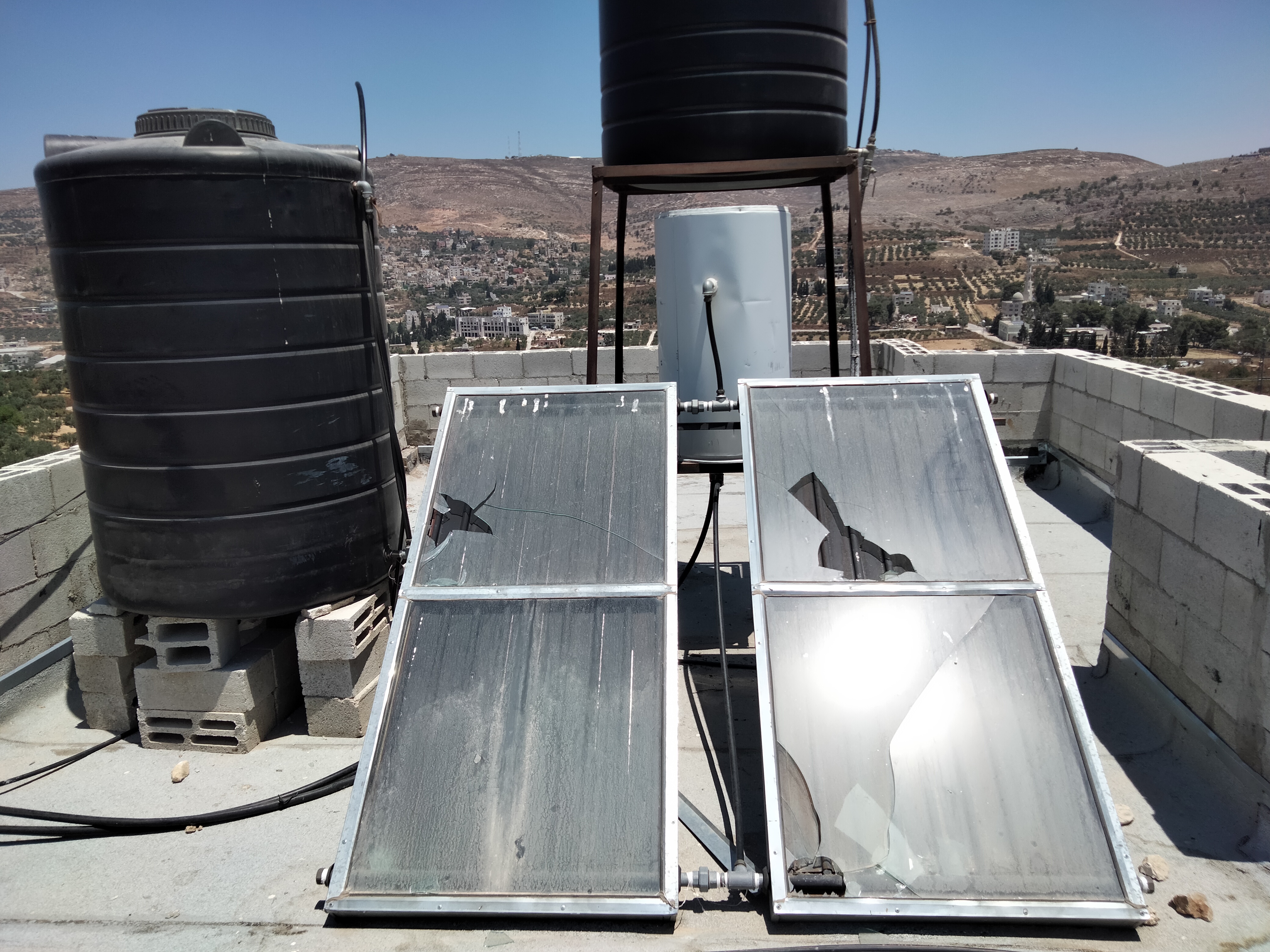 زجاج السخّان الشمسيّ المحطّم فوق سطح منزل عائلة صفوان. تصوير سلمى الدّبعي، بتسيلم، 12.7.21
