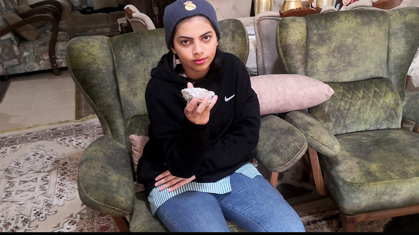 Lin Faraj holding the stone that hit her in the head. Photo by Iyad Hadad, B’Tselem, 24 Nov. 2021