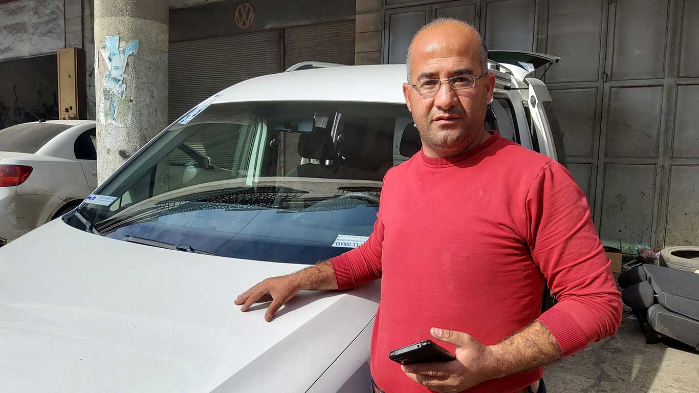 Bassem Salawdah next to his car after the windows were replaced. Photo by Salma a-Deb’i, B’Tselem, 25 Nov. 2021