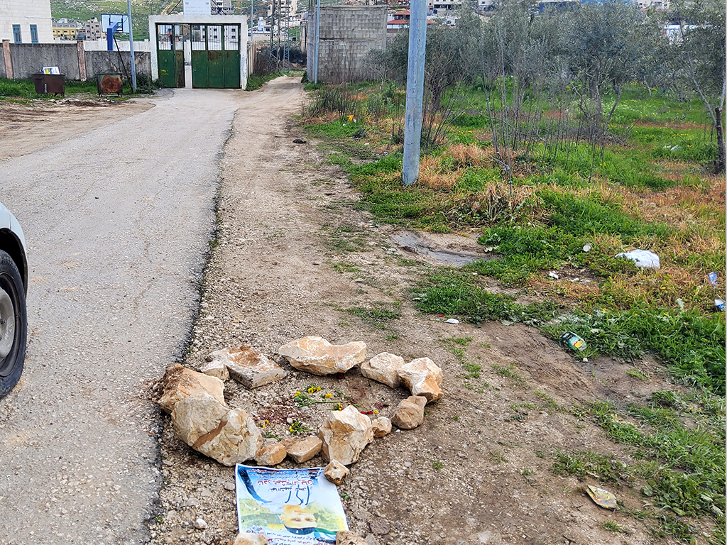 A poster commemorating Rayan and a memorial at the site where he was killed. The school gate is seen further down. Photo by Salma a-Deb’i, B’Tselem, 16 Mar. 2022