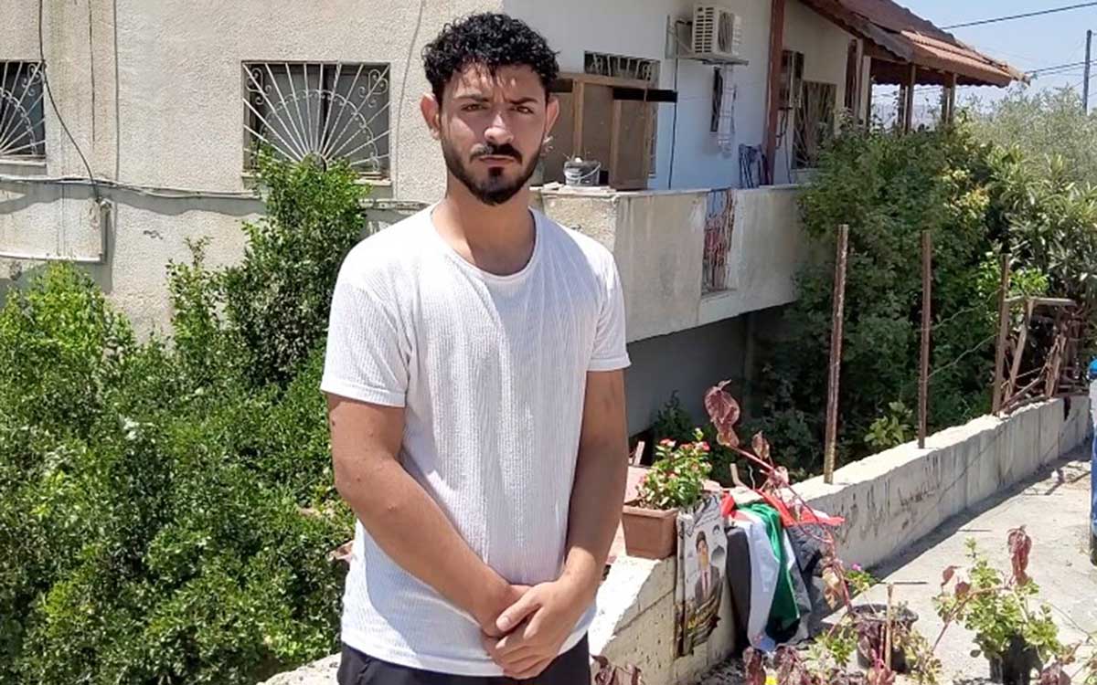 Muhammad Mukheimar next to the makeshift memorial for his friend. Photo: Salma a-Deb'i
