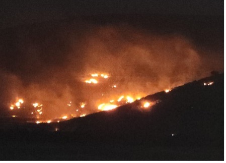 Burning bales of wheat torched by settlers. Photo courtesy of local residents.  