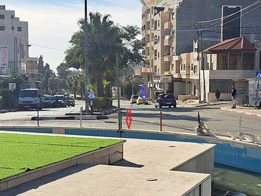 כיכר הפירות בביתוניא. החץ הסגול מצביע על המקום שבו עמד השוטר היורה והאדום על המקום שבו נורה פאדי בדראן. צילום: איאד חדאד, בצלם, 3.12.23