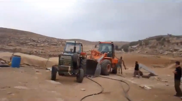 מתנחלים מגיעים לקהילה כשאחד מהם חמוש ברובה. מתוך תיעוד וידאו, באדיבות אחד התושבים