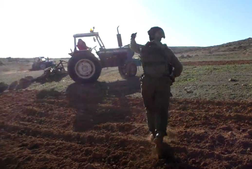 A soldier ordering a Palestinian to stop plowing private land owned by residents of Sadet a-Thala’h, South Hebron Hills. Photo: Solidarity activists, 4 Jan. 2024