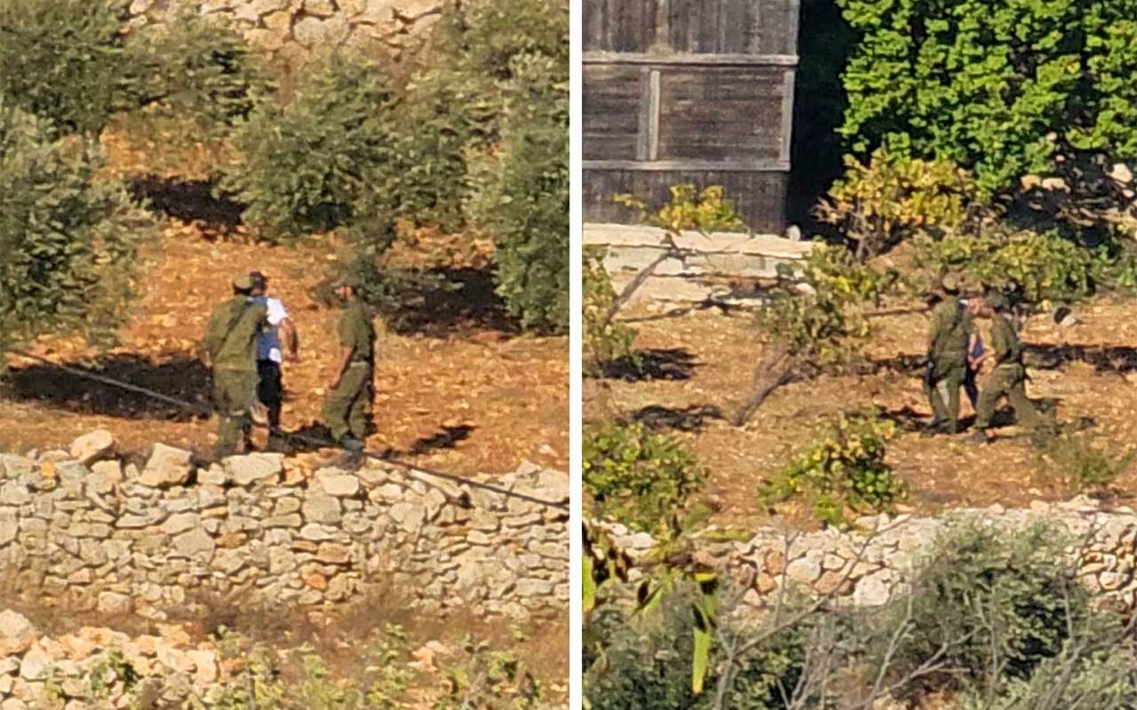 Soldiers detain the laborers working by the agricultural structures. Photo courtesy of residents 