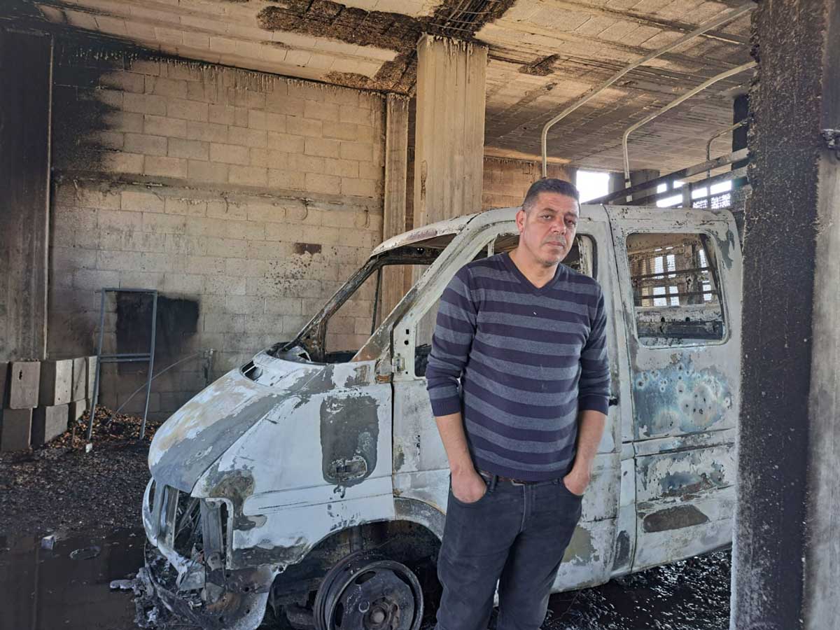 محمد شحادة بجانب شاحنته التي أحرقها المُستوطنون. تصوير: سلمى الدّبعي، بتسيلم، 4.12.24