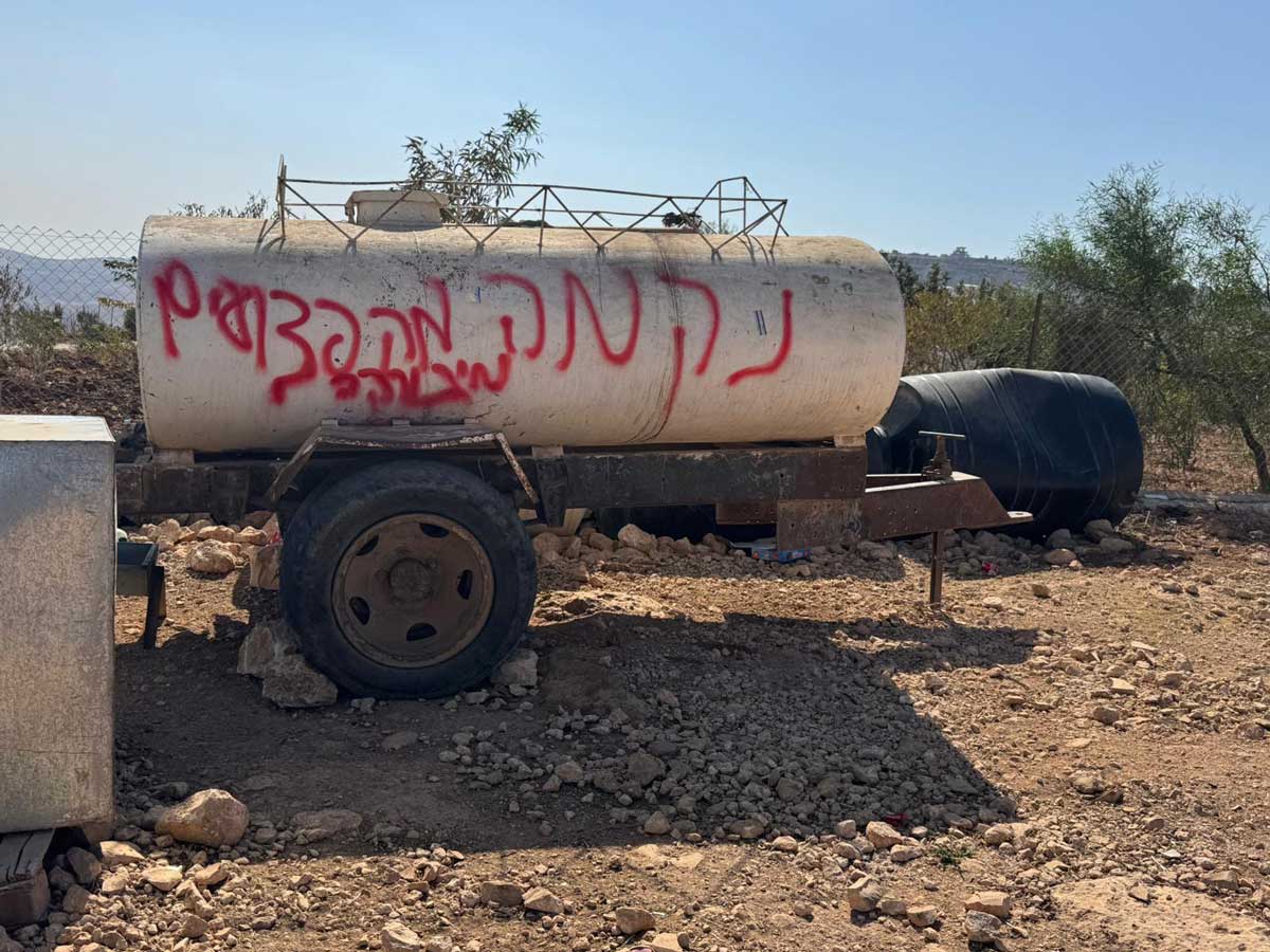 הכתובת שריססו המתנחלים על מכלית המים. צילום: מוחמד רומאנה, בצלם