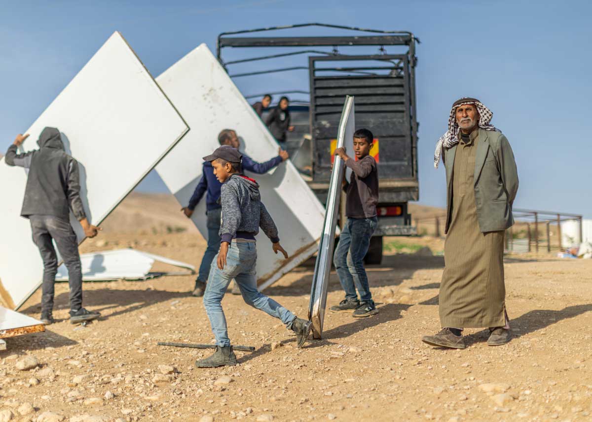 תושבים בראס עין אל-עוג'א מעמיסים חלקי מבנים שפורקו על משאית לקראת עזיבה. צילום: אבישי מוהר, בצלם, 8.1.26