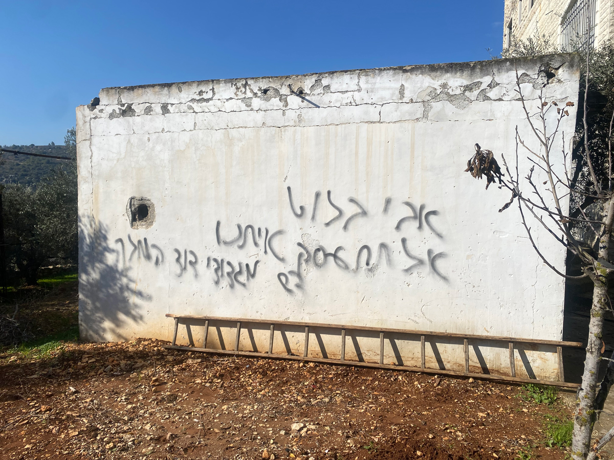 Hate graffiti on the garage wall. Photo: Mohammad Romaneh, B’Tselem