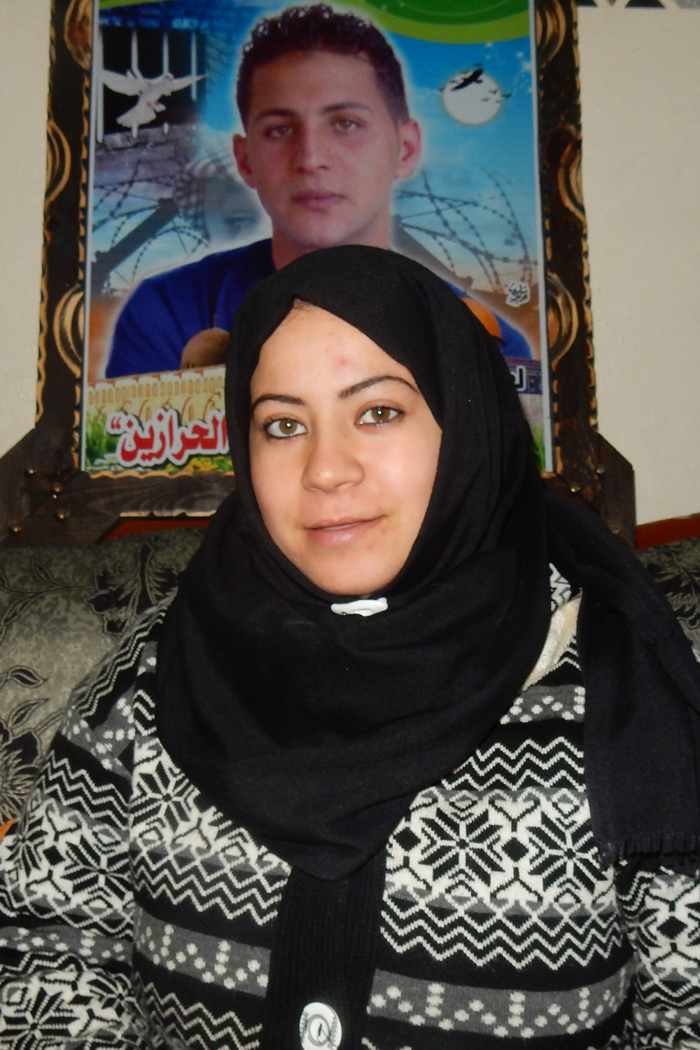 מאדלין אל-חלולי עם תמונת אחיה. צילום: אולפת אל-כורד, בצלם, 12.12.17