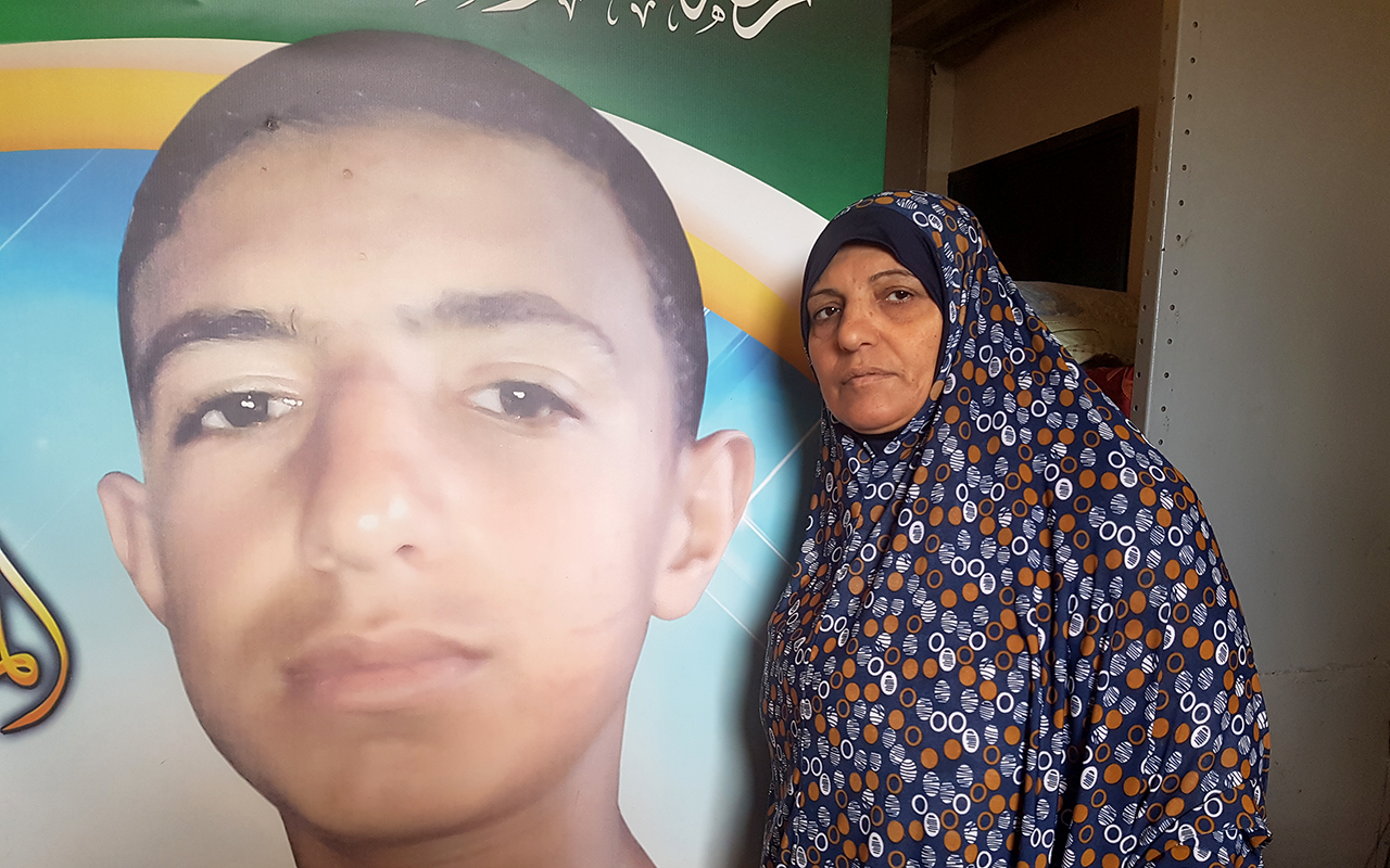 Iftikhar Abu Habel next to a poster in memory of her son. Photo by Olfat al-Kurd, B'Tselem, 9 Oct. 2018