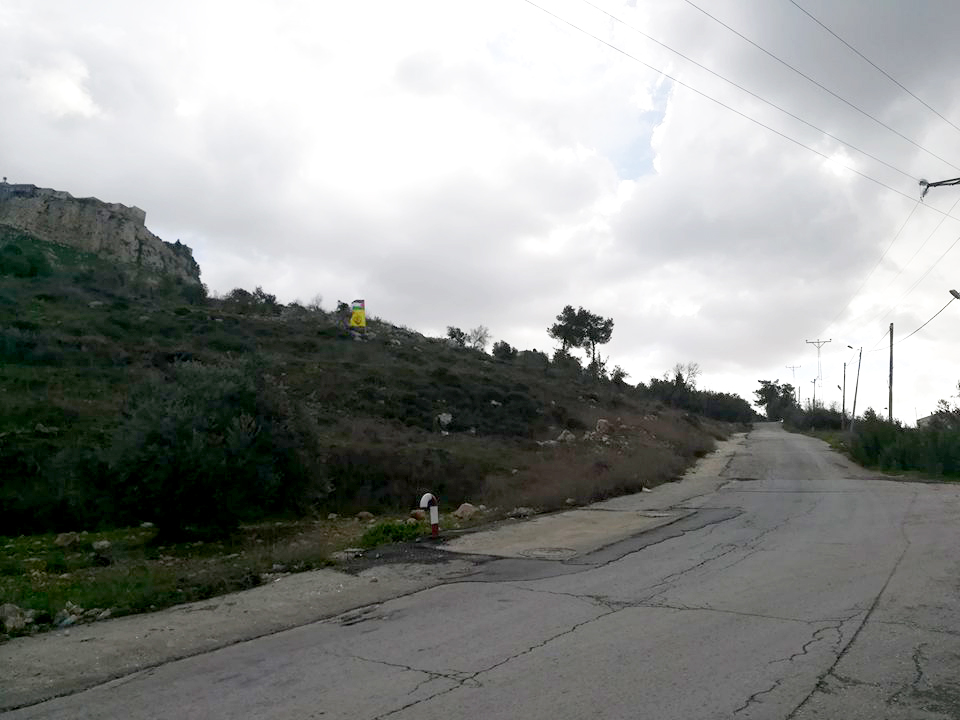علم فلسطين مرفوعًا فوق التلّة في الموقع الذي قُتل فيه علي قينو. تصوير: سلمى الدّبعي، 14.1.2018