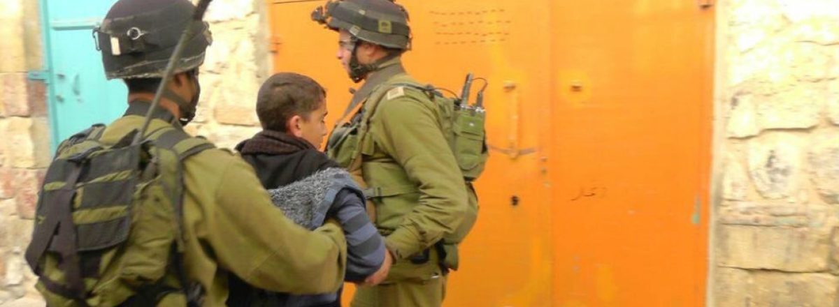 חיילים עוצרים נער פלסטיני בחברון. צילום: מנאל אל-ג'עברי, בצלם, 1.1.12