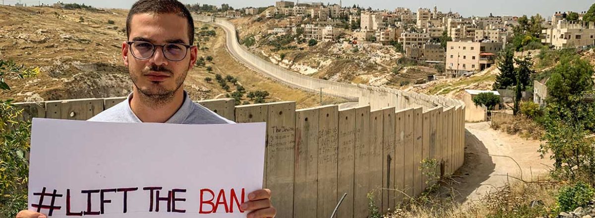 ליית' אבו זיאד על רקע גדר ההפרדה. התמונה באדיבות אמנסטי אינטרנשיונל