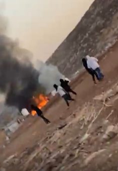 Settlers by a home going up in flames in Khallet a-Sidrah. Photo: Torat Tzedek 