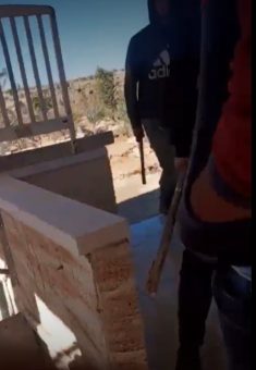 Settlers with clubs in the agricultural structure. Still from video footage, courtesy of the family 