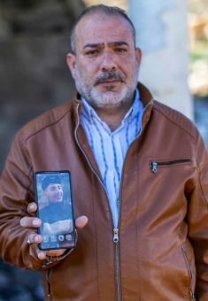 Sa’ed Na’asan with a photo of his son. Photo: Avishai Mohar, B’Tselem