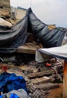 The tent where the family now lives, with the ruins of their home, destroyed in an Israeli strike, visible behind it. Photo courtesy of the witness.