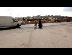 نساء يعبرن شارع رقم 60 بالقرب من مدخل خربة قلقس. الصورة من التوثيق بالفيديو.