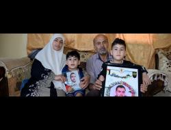 Arwa Snobar's children with her in-laws. Photo by Salma a-Deb'i, B'Tselem, 6 June 2018Arwa and Mustafa Hindi's children holding pictures of their father, with their grandparents. Photo by Salma a-Deb'i, B'Tselem, 6 June 2018
