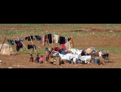 Family by remains of their possessions after most recent demolition. Taken from video footage
