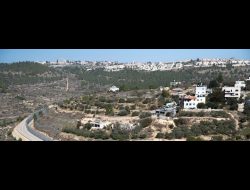 קצה שכונת עין ג'ויזה באל-ולג'ה וגדר ההפרדה על אדמות הכפר על רקע שכונת גילה במזרח ירושלים. צילום: מתן גולן