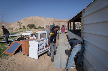 תושבים בראס עין אל-עוג'א מעמיסים חלקי מבנים שפורקו על משאית לקראת עזיבה. צילום: פאיז אבו רמילה, בצלם, 8.1.26 