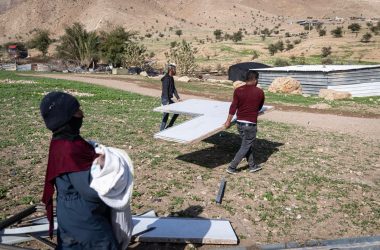 תושבים בראס עין אל-עוג'א מעמיסים חלקי מבנים שפורקו על משאית לקראת עזיבה. צילום: פאיז אבו רמילה, בצלם, 8.1.26 
