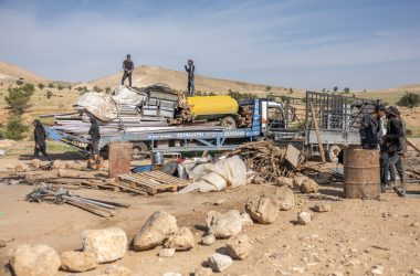   תושבים בראס עין אל-עוג'א מעמיסים חלקי מבנים שפורקו על משאית לקראת עזיבה. צילום: אבישי מוהר, בצלם, 8.1.26 